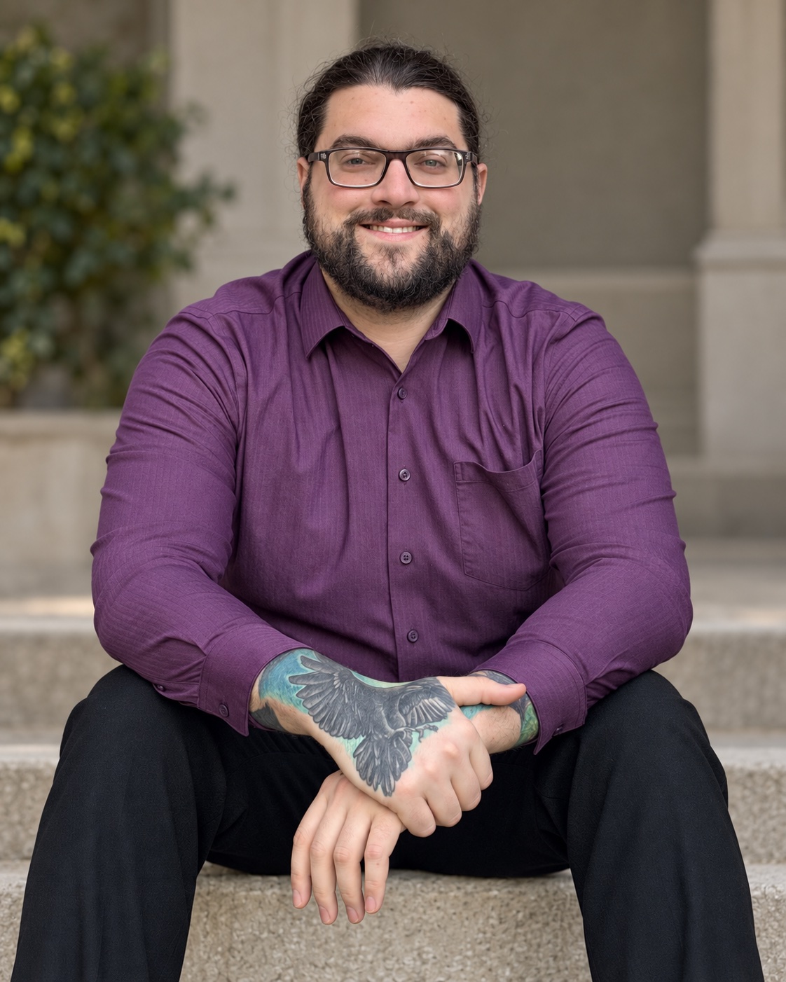 Nicholas Torchio seated in a purple shirt, smiling at the camera